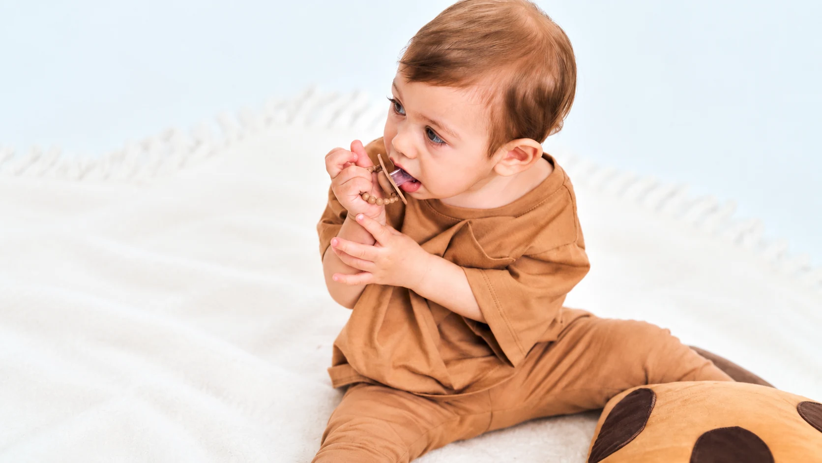 baby chewing a dummy during teething