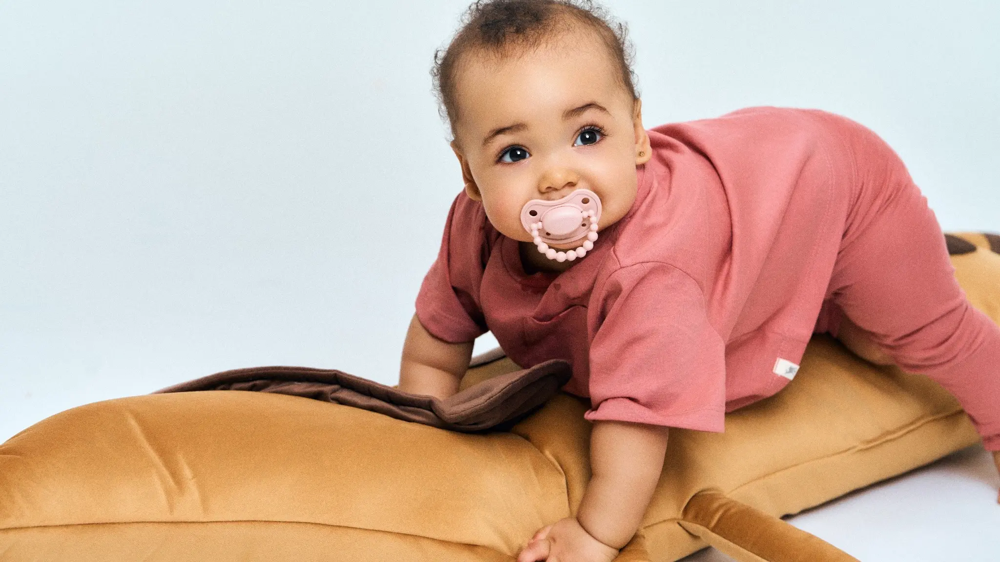 Ein entspanntes, zufriedenes Baby, das bequem einen Schnuller verwendet